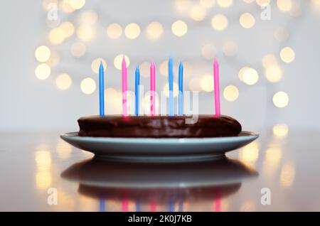 Gâteau d'anniversaire festif avec bougies et décoration de carnaval colorée sur fond de bokeh lumineux. Carte de vœux. Fête et fête Banque D'Images