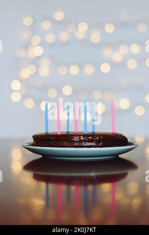 Gâteau d'anniversaire festif avec bougies et décoration de carnaval colorée sur fond de bokeh lumineux. Carte de vœux. Fête et fête Banque D'Images