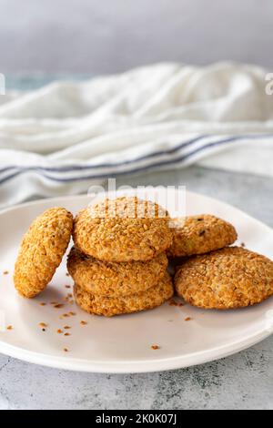 Biscuits au sésame. Petits gâteaux salés fraîchement cuits sur fond gris. Gros plan Banque D'Images