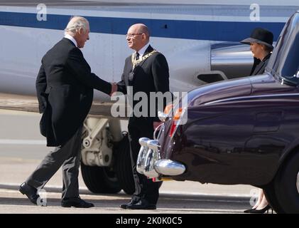 Le premier ministre d'Écosse Nicolas Sturgeon attend de saluer le roi Charles III alors qu'il tremble la main avec Robert Aldridge Lord Provost d'Édimbourg sur l'Arival à l'aéroport d'Édimbourg après avoir voyagé de Londres avec le Queen Consort, Avant de rejoindre la procession du cercueil de la reine Élisabeth depuis le palais de Holyroodhouse jusqu'à la cathédrale Saint-Giles, Édimbourg. Date de la photo: Lundi 12 septembre 2022. Banque D'Images