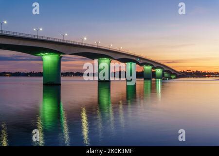 Pont de Ringling à Sarasota, Floride au coucher du soleil avec des fermes éclairées de vert. Banque D'Images