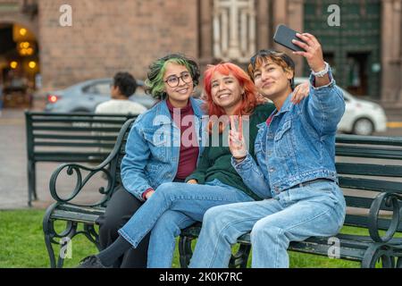 Des amies qui prennent des photos de selfie sur un téléphone portable tout en se reposant dans la ville de Cusco Banque D'Images