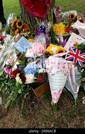 Des bouquets , des hommages écrits, des jouets en peluche, des bougies et des cartes ont été posés en l'honneur de la Reine Elizabeth à Green Park et des milliers de personnes ont continué à affluer à la résidence royale Buckingham Palace dans le centre de Londres. Banque D'Images