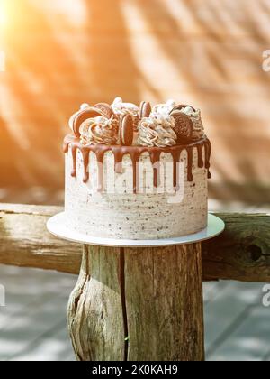 Beau gâteau rond avec chocolat et biscuits sur bois rond. Carte de vœux Banque D'Images