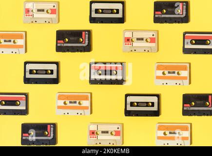 Motif rétro avec cassettes audio sur fond jaune. Banque D'Images