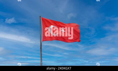 Drapeau turc agitant dans un ciel bleu ciel nuageux. Banque D'Images