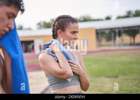 femme essuyant sa sueur après un dur entraînement Banque D'Images