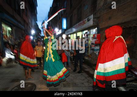 Bhaktapur, Bagmati, Népal. 12th septembre 2022. Des personnes décorées de couleurs différentes dans leurs visages font le tour de la ville de Baktapur pour marquer le festival de Mupatra à Bhaktapur. Au cours de la procession, il est d'usage pour trois personnes, dont le chef Mupatra et deux autres assistants nommés Dhischa, de s'habiller comme des monstres, de tenir des épées dans des couleurs différentes sur leurs visages et des faire marcher dans la ville. Tout en encerclant la ville, le démon Mupatra tourne trois fois et frappe Yamadyo, qui se trouve sur la place de péage des dévotés, avec une épée. (Image de crédit : © Amit Machamasi/ZUMA Press Wire) Banque D'Images