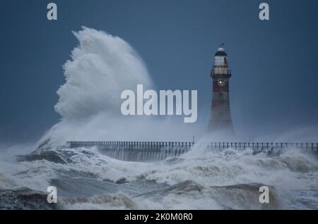 D'énormes vagues frappent le phare sur Roker Pier, Sunderland, Tyne & Wear, Angleterre, Royaume-Uni, pendant une tempête d'hiver Banque D'Images