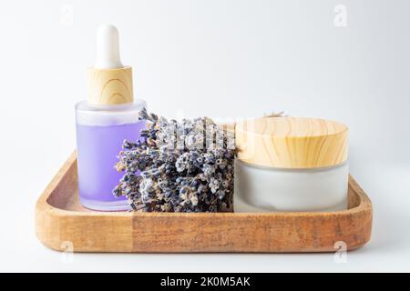 Huiles de lavande sérum, crème et fleurs de lavande sur plateau en bois produits cosmétiques pour le soin de la peau. Mettez en place des produits de beauté naturels. Huile essentielle de lavande, Banque D'Images