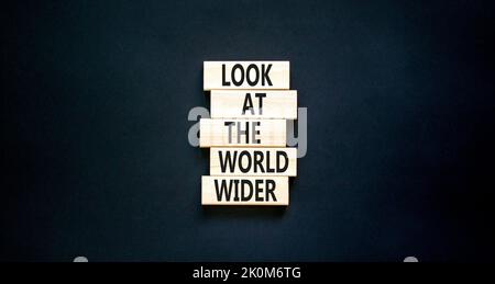 Regardez le symbole du monde entier. Les mots de concept regardent le monde plus large sur des blocs de bois sur un beau tableau noir fond noir. Affaires et look Banque D'Images