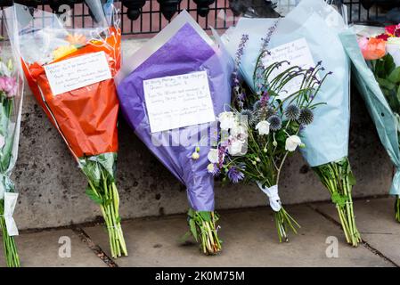 Fleurs et messages laissés à l'extérieur du palais de Buckingham après la mort de la reine Elizabeth II La remerciant pour son devoir. Groupe orange et bleu Lambeg Banque D'Images