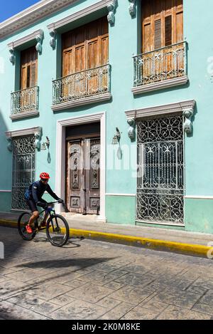 Cycliste conduisant devant un bâtiment colonial, Merida Mexico Banque D'Images