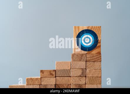 Cllase up photo de l'échelle faite de blocs de bois et le signe de cible sur le dessus comme un symbole d'escalade ou de travail dur pour les buts et les cibles. Banque D'Images