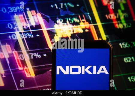 KONSKIE, POLOGNE - 10 septembre 2022: Smartphone affichant le logo de la société Nokia sur fond de diagramme boursier Banque D'Images