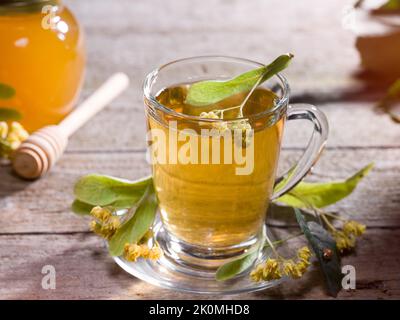 Un verre de thé de linden avec du miel de linden sur la table. Concept de thés d'hiver sains Banque D'Images