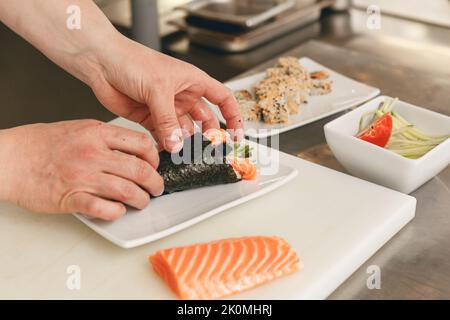 Gros plan sur l'homme restaurant japonais chef cuisinier de sushi dans la cuisine Banque D'Images