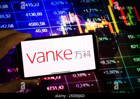 KONSKIE, POLOGNE - 10 septembre 2022: Smartphone affichant le logo de la société Vanke sur fond de diagramme boursier Banque D'Images