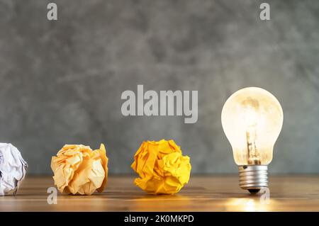 Gros plan photo de papier coloré émietté et ampoule dans le même cadre qu'un symbole de résistance, de persévérance et de travail acharné. Banque D'Images