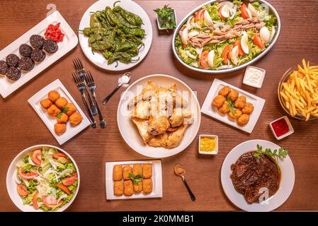 Recettes de plats espagnols typiques et tapas avec croquettes de saveurs diverses, salade avec thon et tomate, poivrons padron frits, poulet haché et Banque D'Images