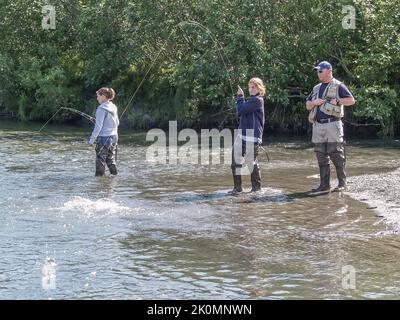 Alaska États-Unis 11 août 2008; jeunes femmes côté de la rivière Alaskan dans les waders pêche au saumon avec guide de pêche. Banque D'Images