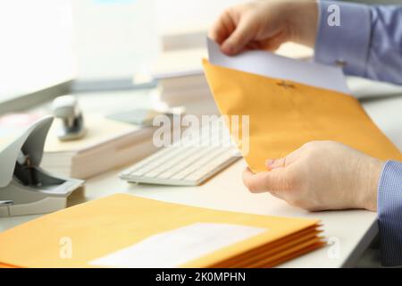 Homme d'affaires sort les documents de l'enveloppe jaune Banque D'Images