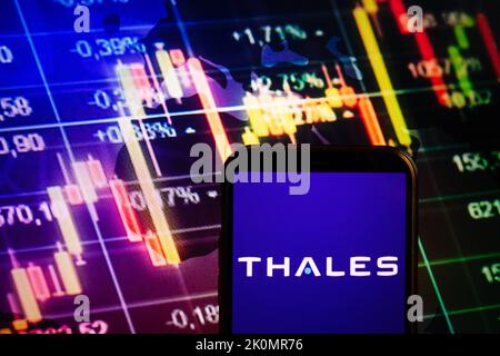 KONSKIE, POLOGNE - 10 septembre 2022: Smartphone affichant le logo de la société Thales sur fond de diagramme boursier Banque D'Images