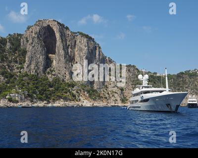 superyacht ancré près de la côte de Capri avec la célèbre formation de roche d'une grotte effondrée. Capri, Campanie, Italie Banque D'Images