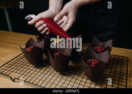 le processus de remplissage des cupcakes au chocolat avec de la confiture. Banque D'Images