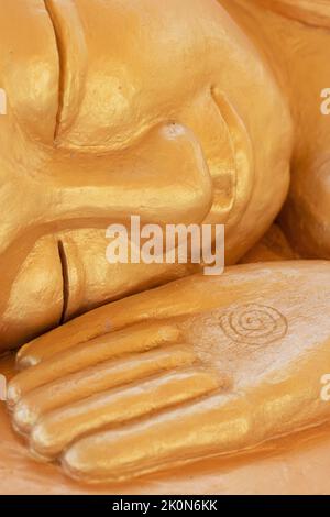 Gros plan sur le visage et la main d'une statue de Bouddha dormant en or, au monastère bouddhiste cambodgien Watt Munisotaram à Hampton, Minnesota. Banque D'Images