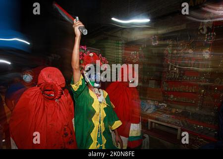 Bhaktapur, Bagmati, Népal. 12th septembre 2022. Des personnes décorées de couleurs différentes dans leurs visages font le tour de la ville de Baktapur pour marquer le festival de Mupatra à Bhaktapur. Au cours de la procession, il est d'usage pour trois personnes, dont le chef Mupatra et deux autres assistants nommés Dhischa, de s'habiller comme des monstres, de tenir des épées dans des couleurs différentes sur leurs visages et des faire marcher dans la ville. Tout en encerclant la ville, le démon Mupatra tourne trois fois et frappe Yamadyo, qui se trouve sur la place de péage des dévotés, avec une épée. (Image de crédit : © Amit Machamasi/ZUMA Press Wire) Banque D'Images