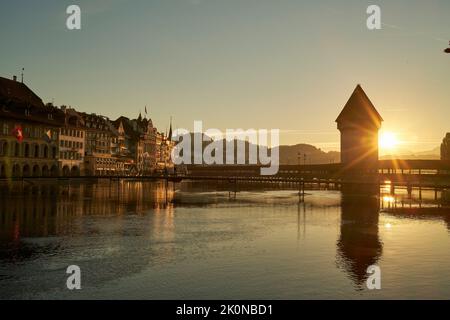 Ancienne tour et pont traversant la rivière sous le ciel de coucher de soleil en Suisse Banque D'Images