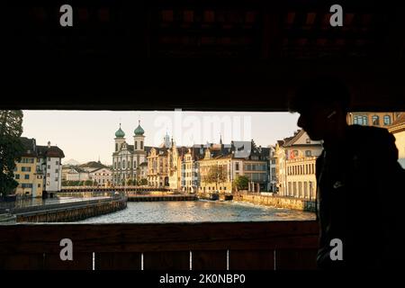 Homme anonyme se promenant sur la passerelle au-dessus de la rivière dans la vieille ville Banque D'Images