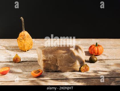 Composition de style rétro en gourde, citrouille, abricot et roc sur une ancienne table en bois. Podium de produits, adapté à l'affichage des produits. Arrière-plan sombre. Banque D'Images