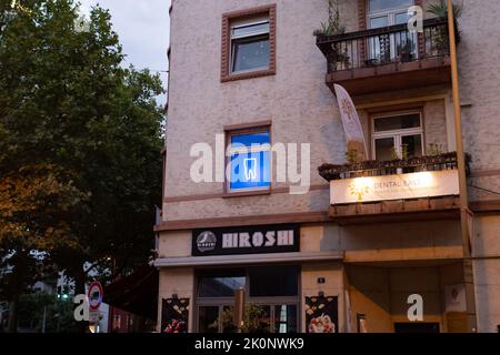 Dent bleue luminante dans une fenêtre d'un dentiste. Publicité avec un néon dans la ville. Pratique dentaire est dans la ville allemande. Service de santé Banque D'Images