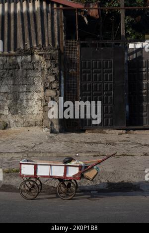 Chariot à main dans la rue devant les bâtiments - scène urbaine Banque D'Images