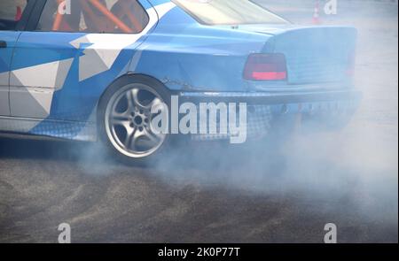 La voiture à propulsion dérive sur la voie asphaltée à l'aide de cônes de sécurité Banque D'Images