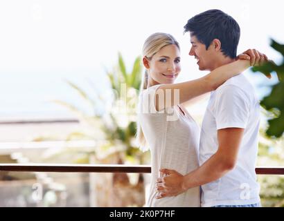 Joyeux lune de miel. Un jeune couple heureux partage un moment affectueux sur le balcon. Banque D'Images