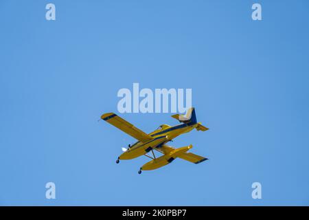 Un hydravion de lutte contre l'incendie vole à travers un ciel clair avant de verser de l'eau sur le feu. Lutte contre l'incendie aérienne. Point de vue ci-dessous. Banque D'Images