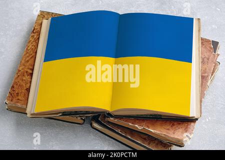 Un livre vintage ouvert avec un drapeau de l'Ukraine imprimé sur une table en béton léger. Histoire de la constitution de l'Ukraine Banque D'Images