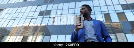 Un homme d'affaires mature aime travailler son pdg contre un immeuble de bureaux Banque D'Images
