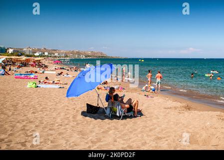 FALIRAKI, GRÈCE - 29 JUIN 2022 : les gens se détendent sur une plage de sable à la station Faliraki sur l'île de Rhodes Banque D'Images