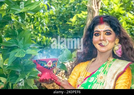 Les femmes mariées exécutant dhunuchi danse à l'occasion de Durga Agomoni comme rituel, la fumée sainte a couvert toute la zone. Banque D'Images