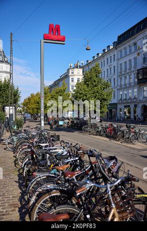 Panneau de métro, station Nørreport, vélos garés en premier plan ; Frederiksborggade Copenhagen, Danemark Banque D'Images