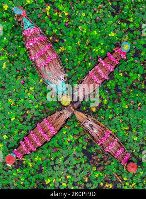 Barishal, Bangladesh. 13th septembre 2022. Les agriculteurs sont vus flotter à travers un canal de plus de 40 kilomètres carrés et ramasser les lilies d'eau à Barishal. Les travailleurs sont vus travailler dès le début de la matinée à partir de 6-8 heures du matin dans le canal en portant des casquettes de tête faites à la main pour protéger leur tête et leur corps pour la chaleur énorme du soleil. Les agriculteurs vendraient les fleurs délicates de rose vif sur le marché local. Les nénuphars roses et les nénuphars verts couvrent le canal et les terres humides de plus de 10 000 acres à Barishal. Les fleurs ne fleurissent qu'à un moment précis de l'inondation saisonnière commençant d'août à novembre. Banque D'Images