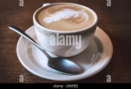 Tasse de café latte sur une ancienne table en bois, gros plan. Banque D'Images