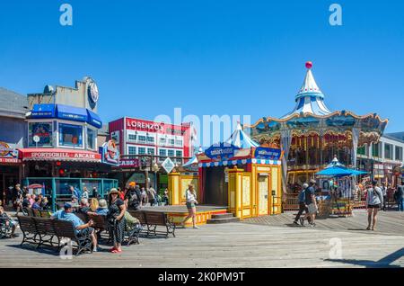 Une vue sur les gens à l'embarcadère 39 avec une promenade en carrousel et une scène pour des spectacles le jour de l'été avec le ciel bleu à San Francisco. Banque D'Images