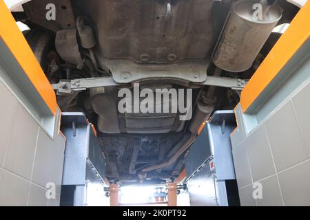 Voiture dans le mécanicien. Vue depuis la fosse, inspection du véhicule Banque D'Images