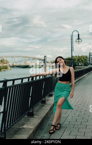 Portrait d'une belle jeune brune sur le pont au bord de la rivière Banque D'Images