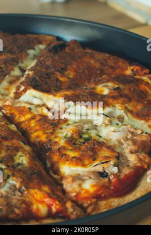 Pizza savoureuse avec mozzarella de buffle fondue, délicieux thon et poivre vert. Restauration rapide savoureuse traditionnelle sur table en bois. Banque D'Images